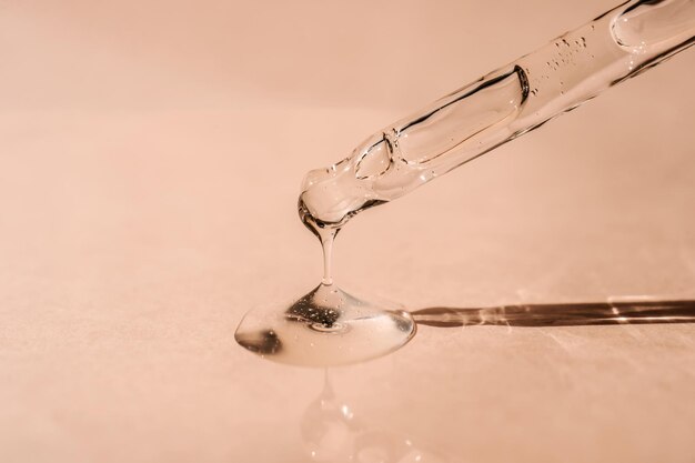 A drop of cosmetic oil falls from the pipette