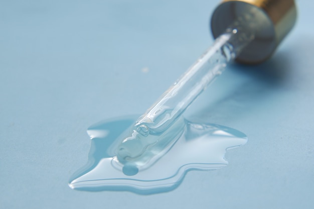 Drop falls from a pipette on flat surface