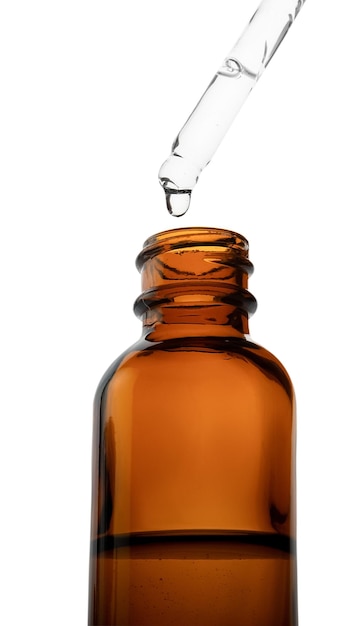 drop falls from a pipette in a medical brown bottle closeup isolated