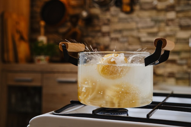 Drop fettuccine pasta into boiling water in a saucepan