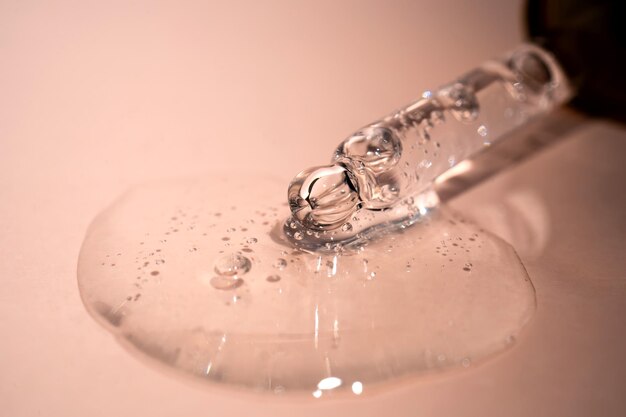 A drop of serum with bubbles on a beige background