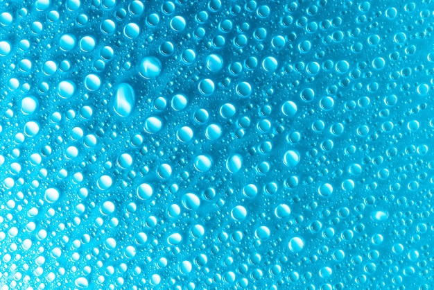 柔らかい光で照らされた青いマット背景の水滴