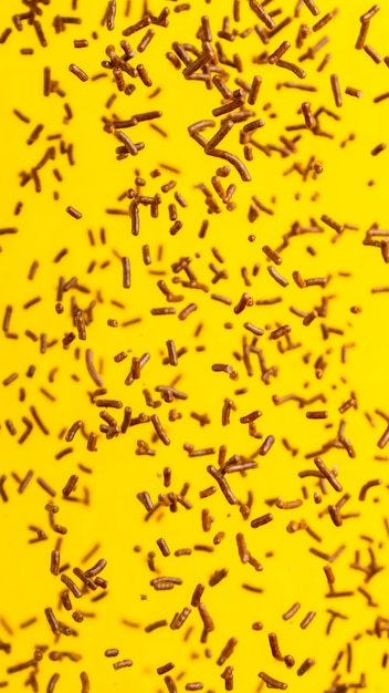 Dropped chocolate sprinkles on the yellow background.