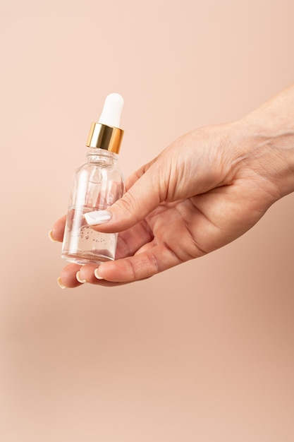 A dropper bottle of gel or serum mockup holding hand presentation