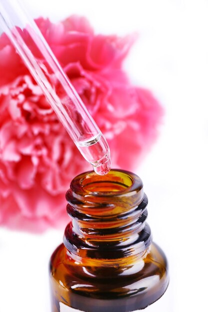 Dropper bottle of perfume with clove on white background