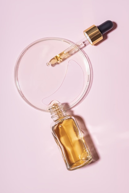 Dropper bottle and petri dish with drops of oil Cosmetic laboratory research Concept beauty hair Selfcare and wellness