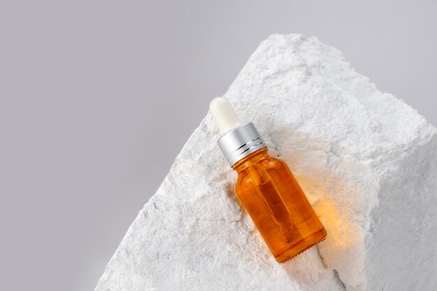 Dropper bottle on stone white background minimal style mock up of beauty product packaging