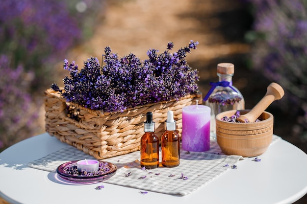 Dropper bottle with lavender cosmetic oil or hydrolate against lavender flowers field as background with copy space Herbal cosmetics and modern apothecary concept