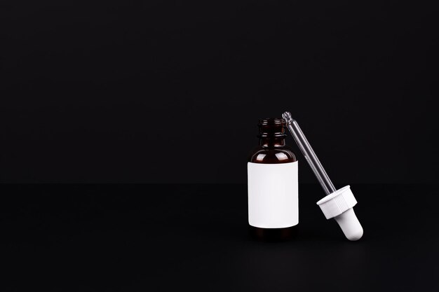 Dropper brown bottle Cosmetic serum glass pipette isolated on black background Essential oil