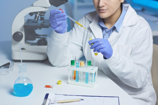 Dropping yellow liquid into test tube