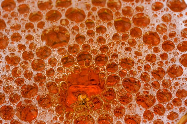 Drops and bubbles of light beer in a glass bullet shot close-up macro photography