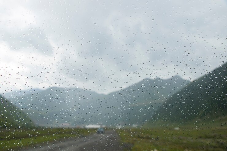 車のガラスと山の風景の背景にドロップ