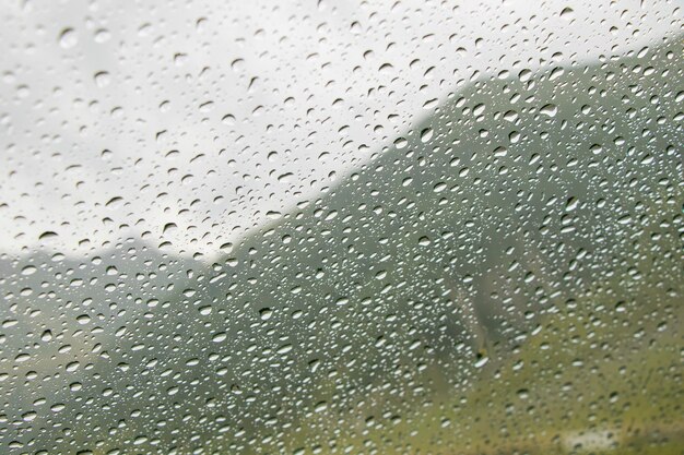 Drops on the car glass and mountain landscape background