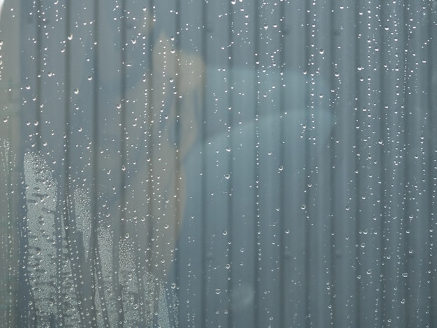 Drops of clean water on the surface of a glass with gray background