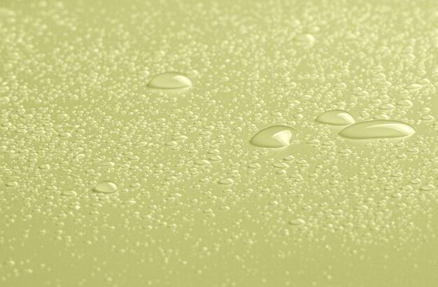 Photo drops of micellar water or cosmetic tonic on a yellow background closeup macro photography