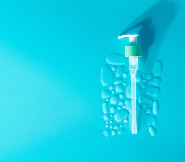 Drops of moisturized serum essential with white dispenser on blue background Flatlay close up