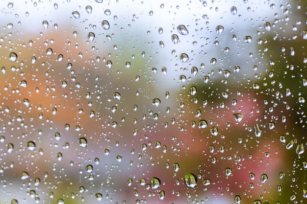 青いガラスの背景に雨のしずく。ストリートボケは、焦点が合っていません。