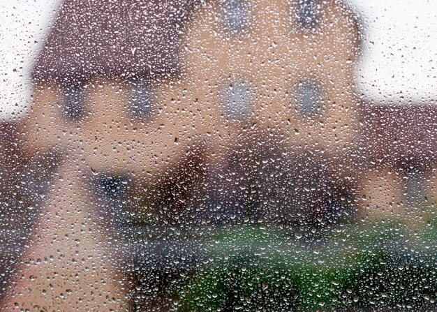 Drops of rain on window against house