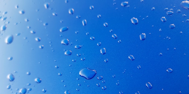 Drops of rainwater on blue metal background