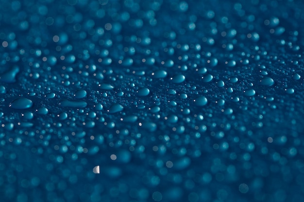 Trama di gocce. acqua blu della pioggia bagnata sul fondo di vetro. modello a bolle.