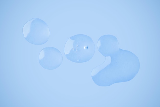 Drops of transparent gel Strokes of gel Smear Gel On a blue background Hyaluronic acid toner toner gel cream Cosmetics