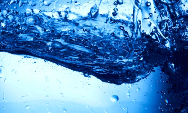Foto gocce d'acqua che cadono nell'acqua blu profondo
