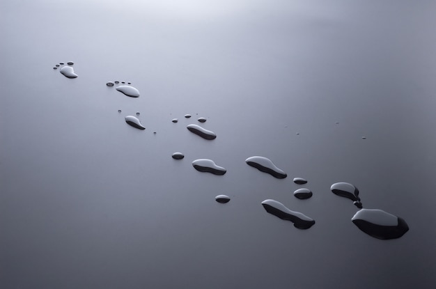 Drops of water splashed in the form of traces of human feet