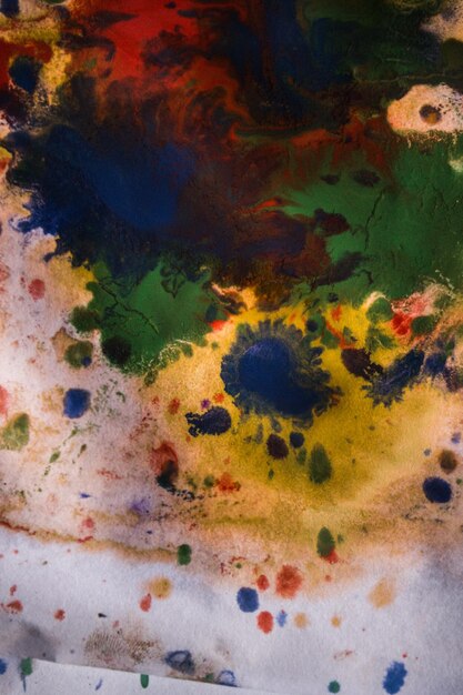 異なる色の絵の具の縞のある滴が混合されて吸収されます