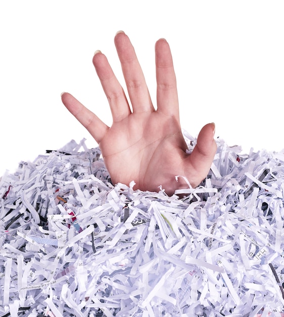 Drowning in destroyed documents Studio shot of a womans hand reaching out from under a pile of shredded paper against a white background