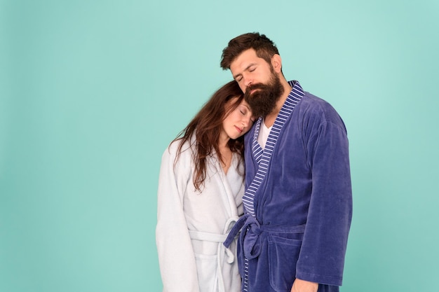 Drowsy and weak in morning Advice relationships surviving quarantine Morning routine Couple sleepy faces domestic clothes All day pajamas Sleepy people blue background Couple in love bathrobes