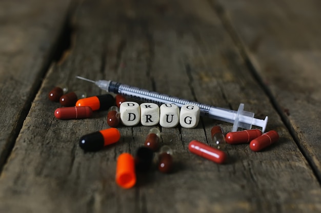 Drug pill on wooden table concept addiction