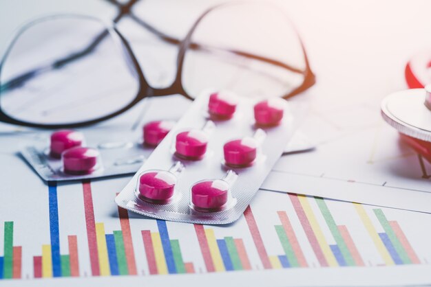 Photo drug, pills and glasses with stethoscope on lab table