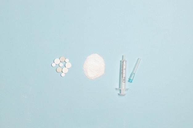 Drugs heroin powder pills and syringes on blue background Healthy lifestyle