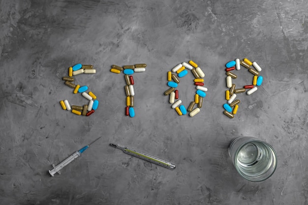 Photo drugs, syringe, thermometer and pills. the inscription stop. concept stop virus coronavirus