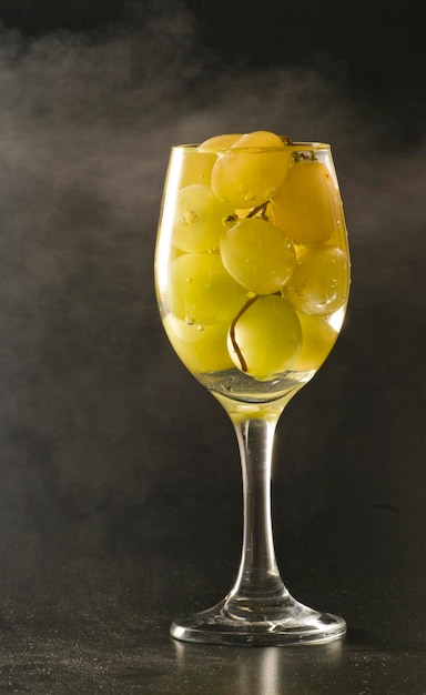 Druiven in een glas tegen een grijze achtergrond