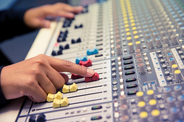 Druk met de hand op de volumeregeling op de geluidsmixer.