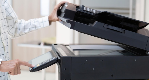 Druk op de knop van de zakenman op het paneel van het netwerk van het printerkopieerapparaat Werken aan fotokopieën in het kantoorconcept printer is kantoormedewerker gereedschapsapparatuur voor het scannen en kopiëren van papier