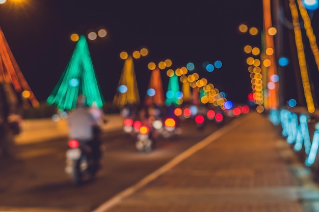 Druk verkeer op een brug 's nachts. Gloeiende brugsteunen. Wazige focus.