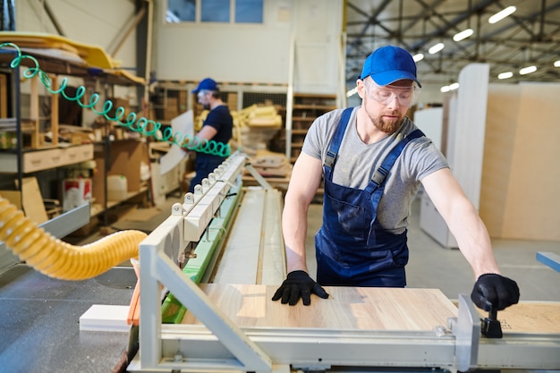 Drukke man aan het werk in de meubelfabriek