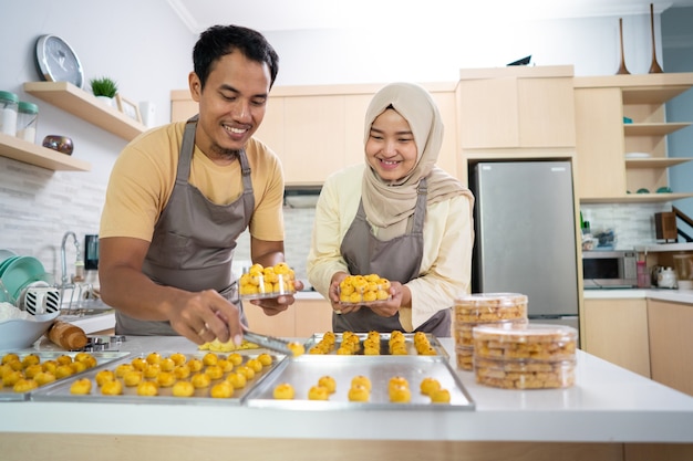 Drukke paar maken samen nastar-snackcake thuis voor eid mubarak-viering samen