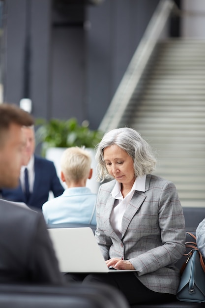 Drukke senior dame op het werk