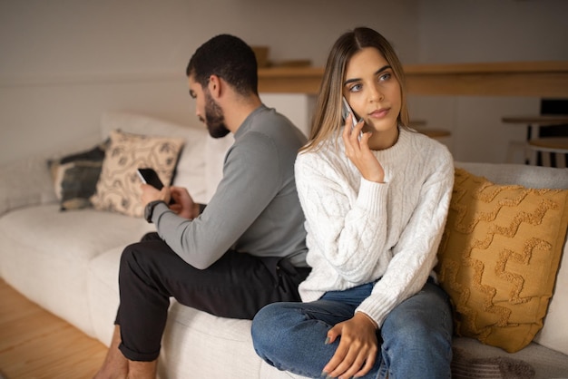 Drukke trieste jonge arabische man die op smartphone typt en Europese vrouw negeert die telefonisch belt