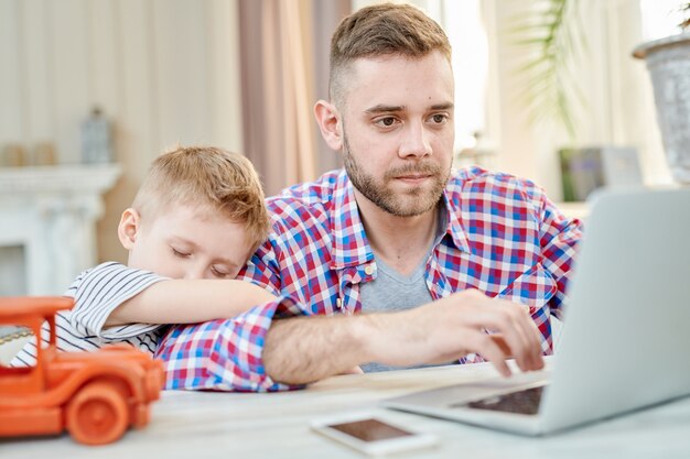 Drukke vader werken bij Laptop