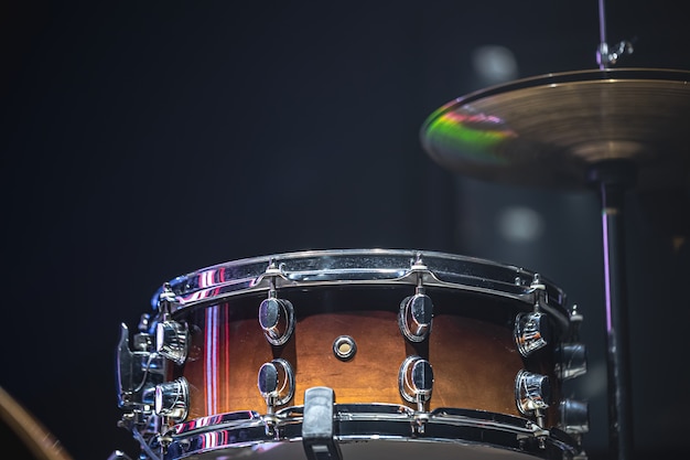 Drum set in a dark room with beautiful lighting, snare drum, cymbals.