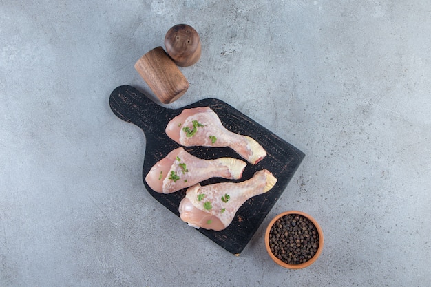 Photo drumsticks on a cutting board, on the marble surface.