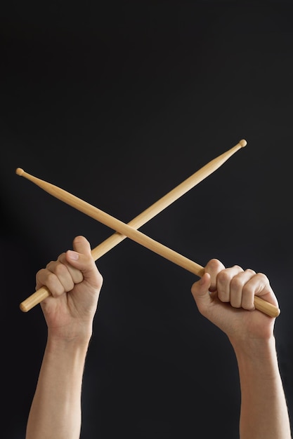 Drumsticks in hands on a black background