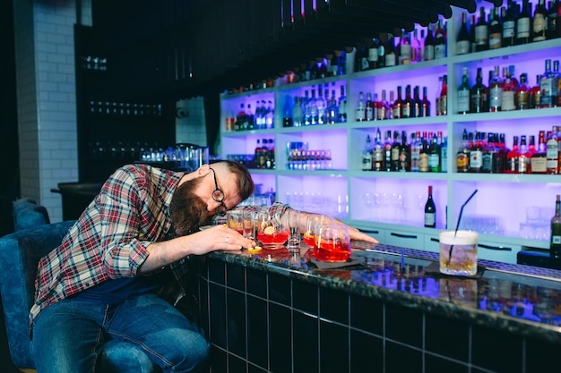 Drunk bearded man fell asleep at the bar