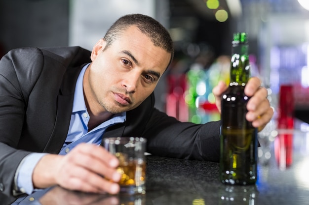 Photo drunk businessman slumped on bar