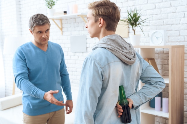 Drunk father angrily asking his son give beer.