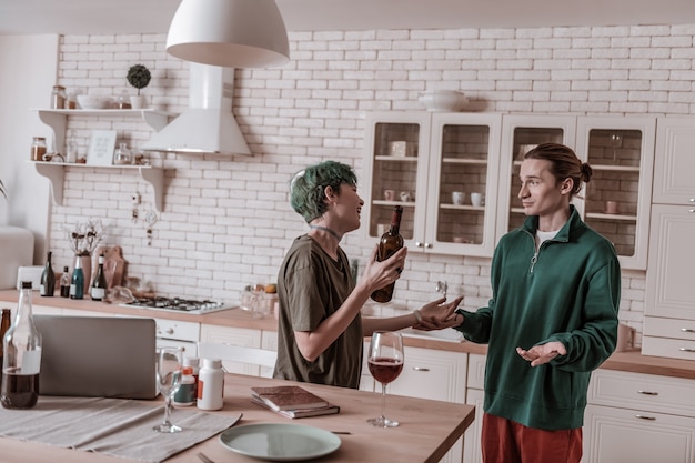 Drunk girlfriend. boyfriend feeling terrified seeing his girlfriend drunk in the morning holding bottle of wine